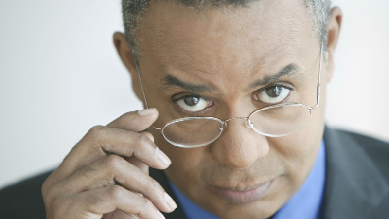 Skeptical man peering over his glasses