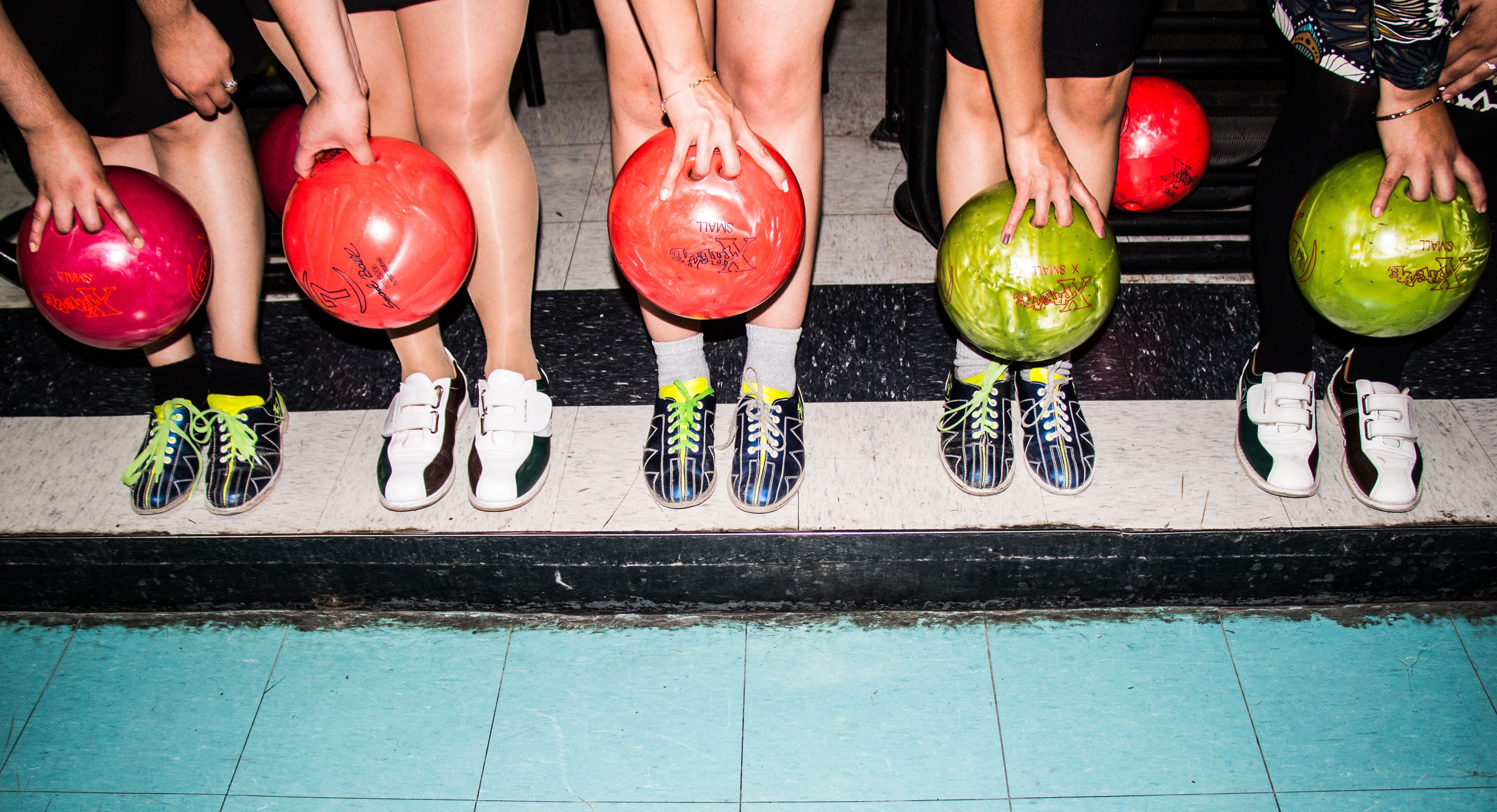 line of people holding bowling balls
